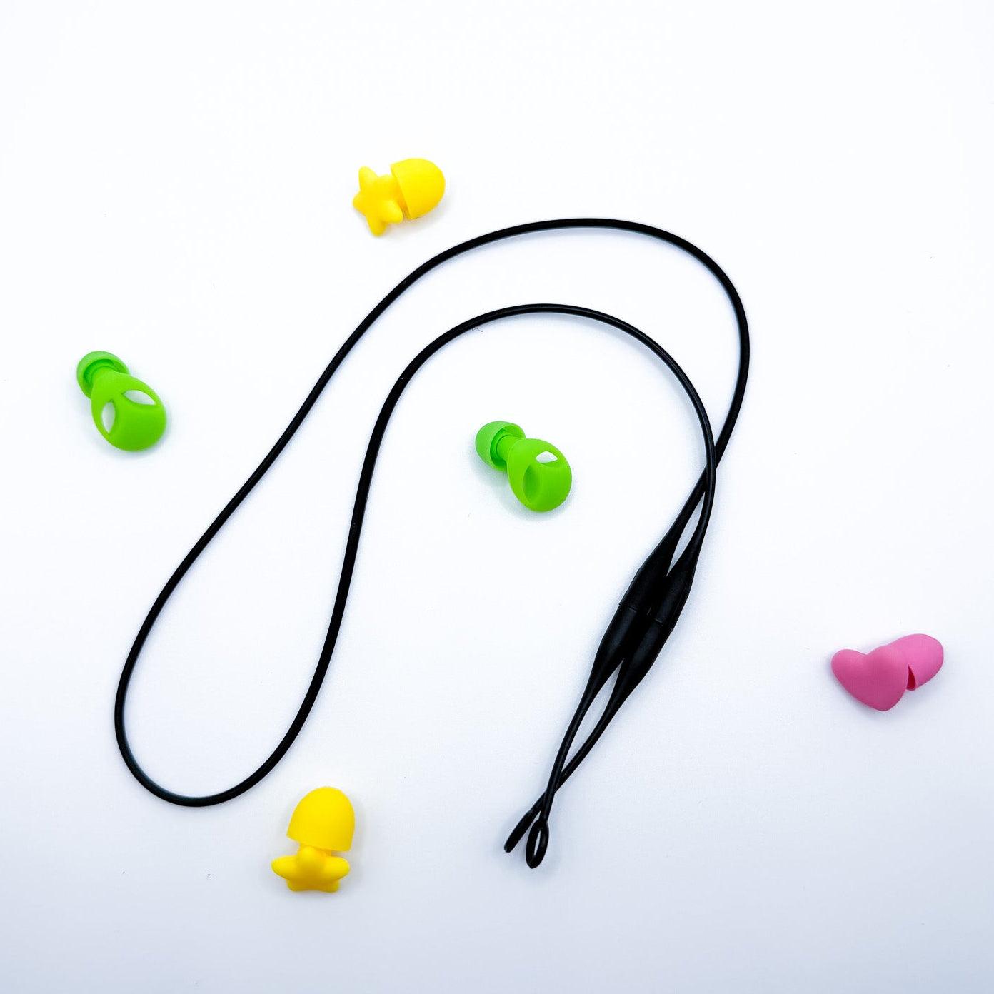 A black elastic neck strap laid out on a white background, surrounded by small colorful silicone ear tips in yellow, green, and pink.