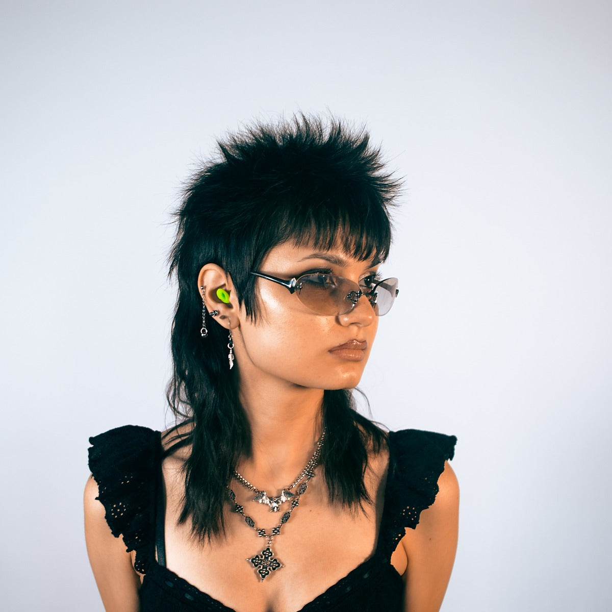 Alien earplug worn in the ear with the charm visible outside, styled as an accessory