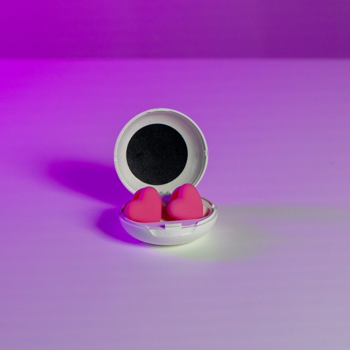 Two pink heart charm earplugs resting together, fashion-forward hearing protection