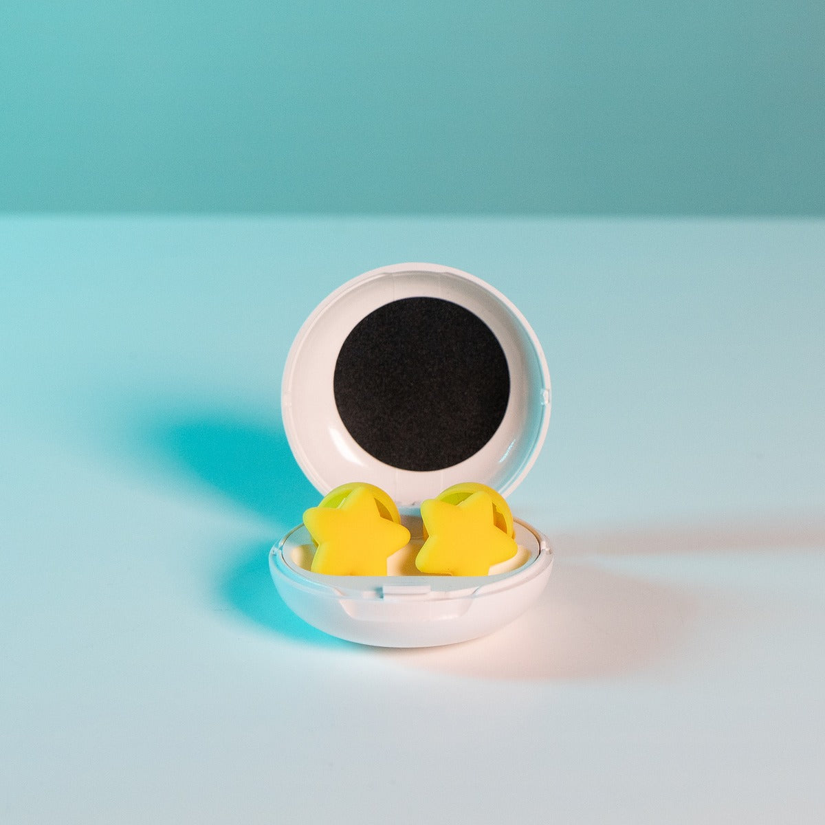 Close-up of two yellow star charm earplugs resting together, fashion-forward hearing protection
